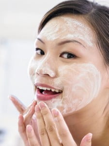 young woman washing face at home