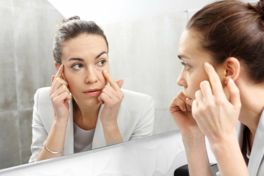 Woman Examines Visible Signs of Stress in the Mirror and Considers Cosmetic Procedures as a Solution