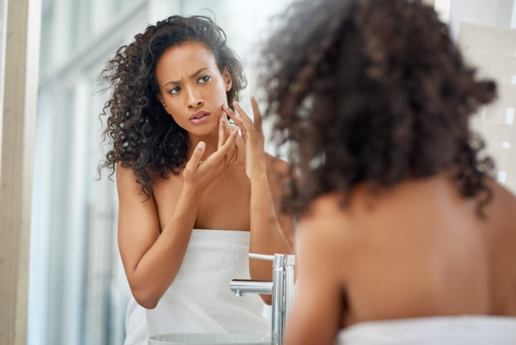 Woman Frowns at Smile Lines as She Examines Face and Skin in Mirror