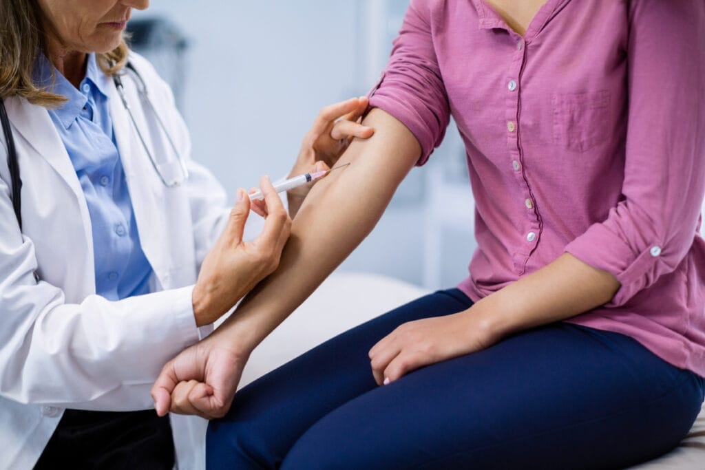 Female physician administering NAD+ injections in the arm